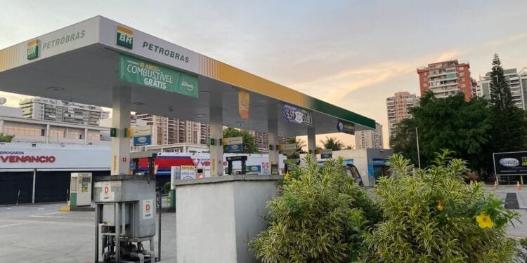 a gas station with trees and buildings in the background